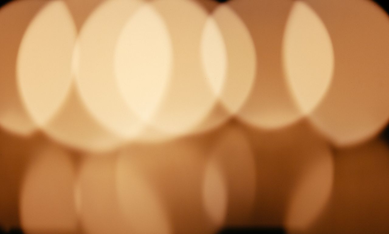 Abstract bokeh lights in warm golden tones create a soft, blurred effect.